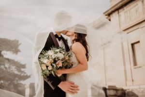Newlywed couple under a veil